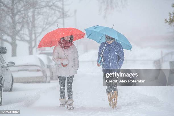 dos chicas adolescentes con paraguas bajo nevadas en la calle - queens new york city fotografías e imágenes de stock