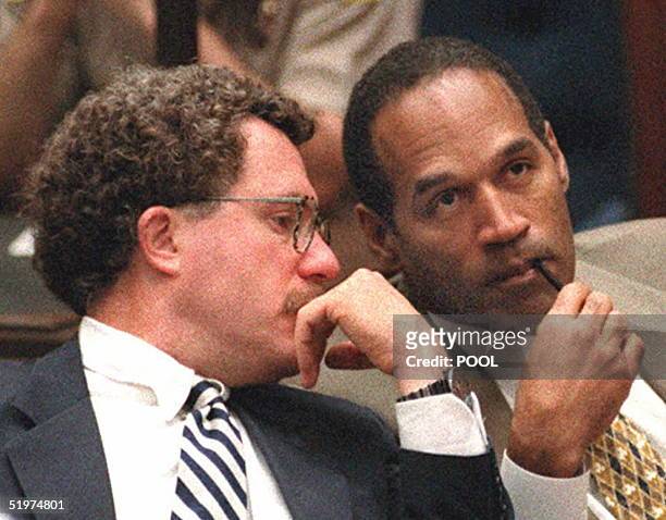 Double murder defendant O.J. Simpson listens to defense attorney Peter Neufeld during testimony by Los Angeles Police Department forensic chemist...