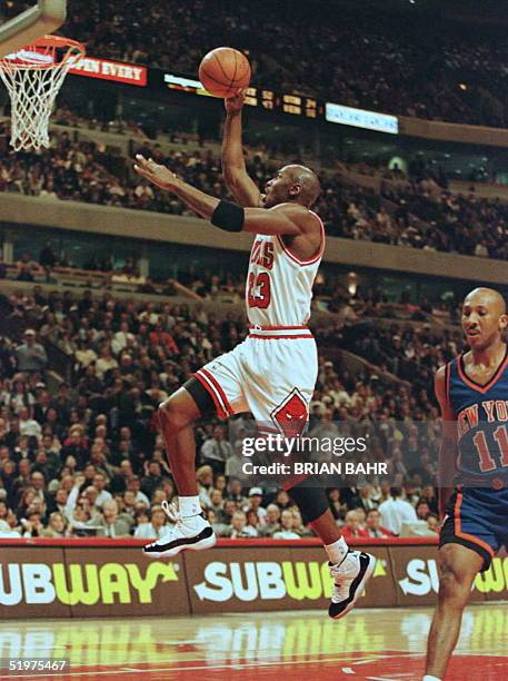 Chicago Bulls' guard Michael Jordan flies to the net on a fast break as New York Knicks guard Derek Harper fails to give chase in the first quarter...