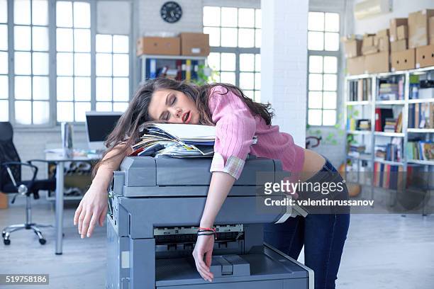 müde assistentin schlafen auf einem kopiergerät - tired worker stock-fotos und bilder