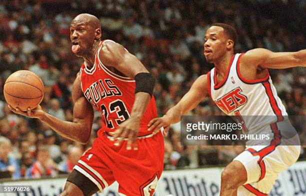Chicago Bulls' Michael Jordan drives for a layup past New Jersey Nets' Chris Childs in first half action 11 April in East Rutherford, New Jersey. The...