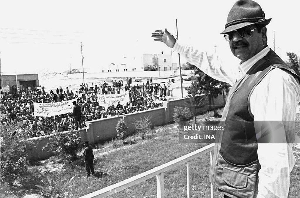 Iraqi President Saddam Hussein waves to supporters
