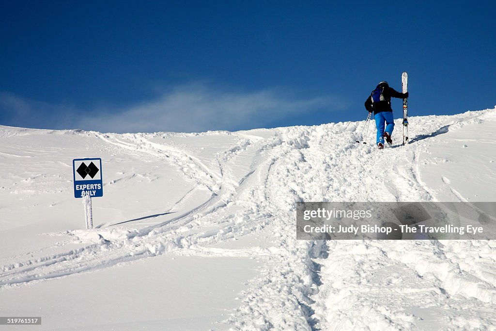 Skier hikes up to "Experts Only" ski run