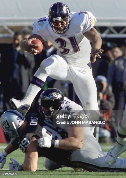 Running back Jamal Lewis of the Baltimore Ravens jumps over his blockers for a gain against the Oakland Raiders in their AFC Championship game 14...