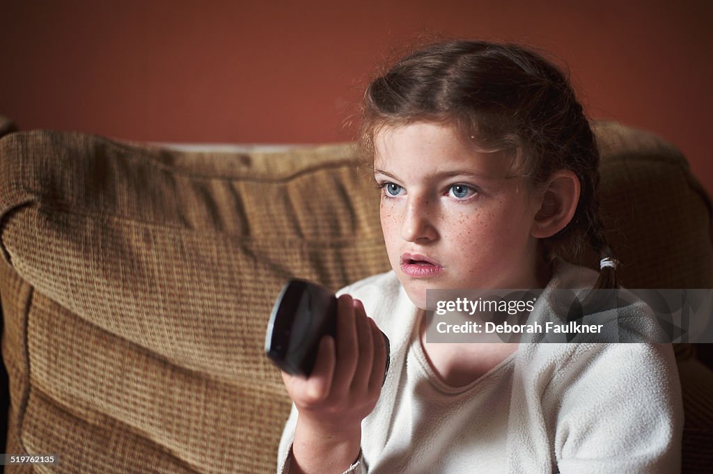 Small girl holding TV remote