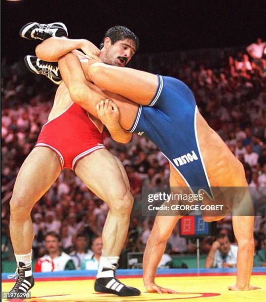 Iran's Abbas Jadidi throws Poland's Marek Garmulewicz during their semi-finals of the men's Olympic freestyle 100kg wrestling 31 July at the Georgia...