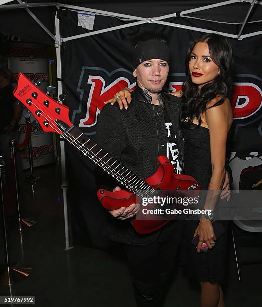 Guitarist Dj Ashba of Sixx:A.M. And his wife, model Nathalia Henao, pose with a guitar during the grand opening of their Ashba Clothing Store at the...