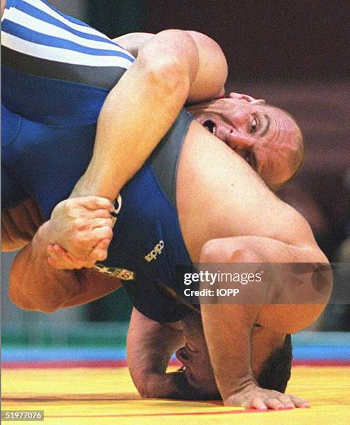 Russia's Alexander Karelin brings down Panayiotis Poikilidis of Greece during their 130kg semi-final Olympic wrestling match 23 July. The Siberian...