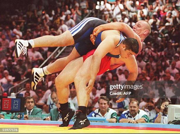 Russian super heavyweight wrestler Alexander Karelin topples opponent Omrane Ayari of Tunisia on his way to winning their 130kg Olympic preliminary...