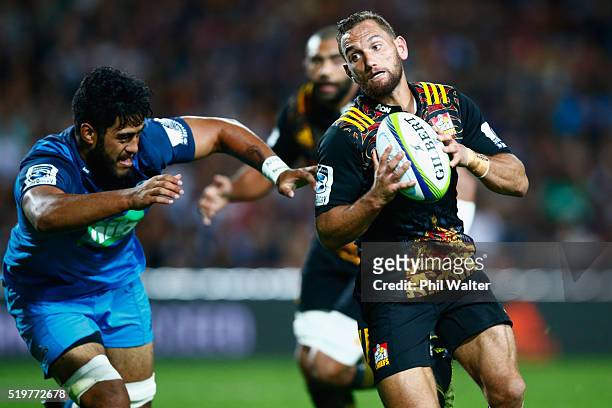 Aaron Cruden of the Chiefs beats the tackle of Akira Ioane of the Blues to score a try during the round seven Super Rugby match between the Chiefs...