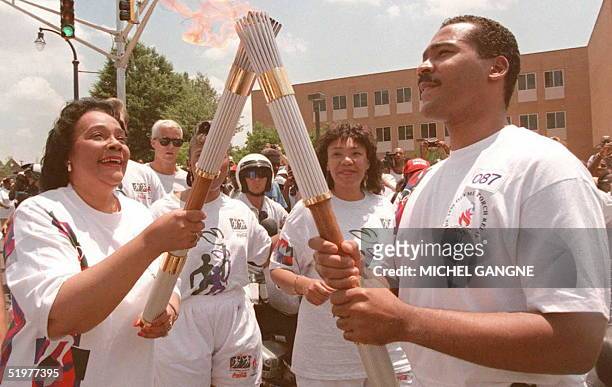 Coretta Scott King , widow of civil rights leader Martin Luther King, passes the Olympic Flame to her son Dexter Scott King 19 July in Atlanta. The...