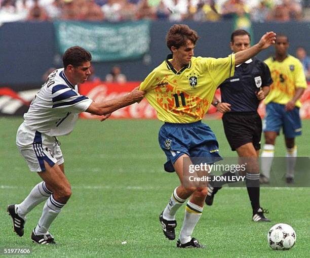 Fernando Hierro of the FIFA world all-stars pulls the arm of Brazil's Savio during first half action of their exhibition game 14 July at Giants...