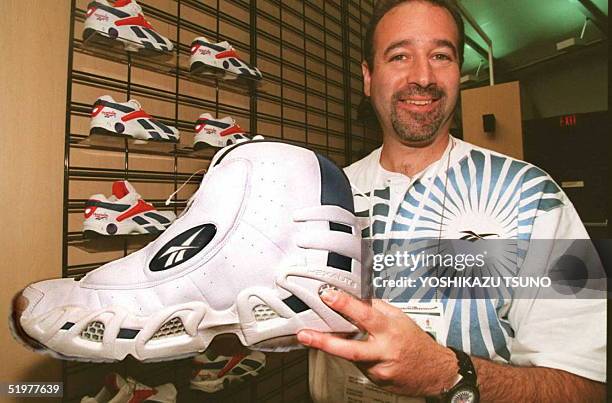 Reebok representative David Rogelson displays US basketball player Shaquille O'Neal's size 22 shoe 13 July at the Reebok Ring in Atlanta. The 26th...