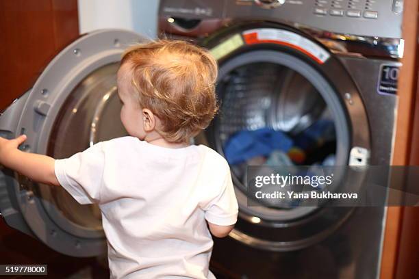 little boy near the washing machine - child proofing stock pictures, royalty-free photos & images