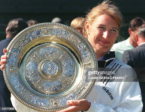 German top seed Steffi Graf holds her trophy after she won her seventh title after beating Arantxa Sanchez Vicario of Spain in the women 's singles...