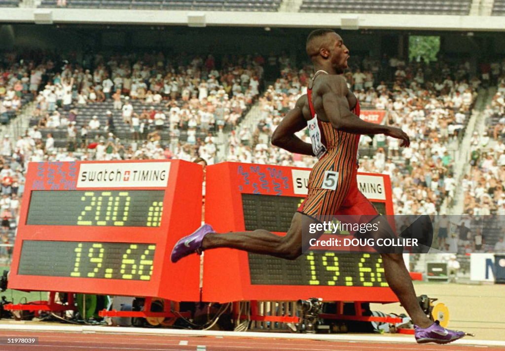 Michael Johnson of the US runs past the clock afte