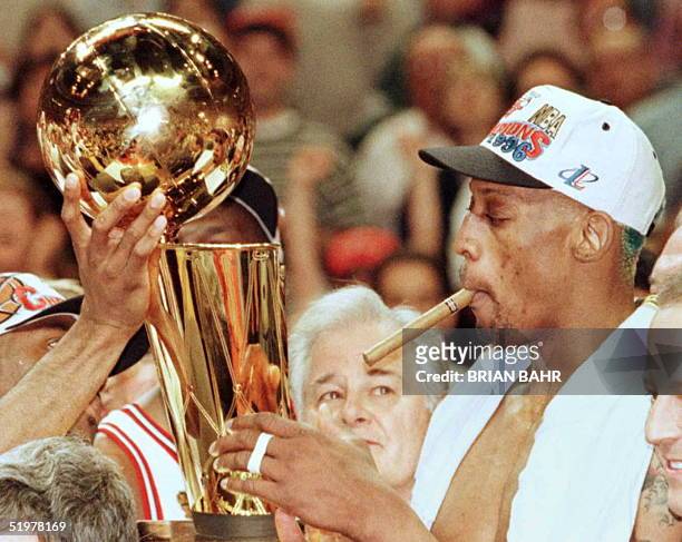 Chicago Bulls Dennis Rodman holds the Larry O'Brian trophy after the Bulls beat the Seattle SuperSonics 87-75 in game six of the NBA Finals at the...