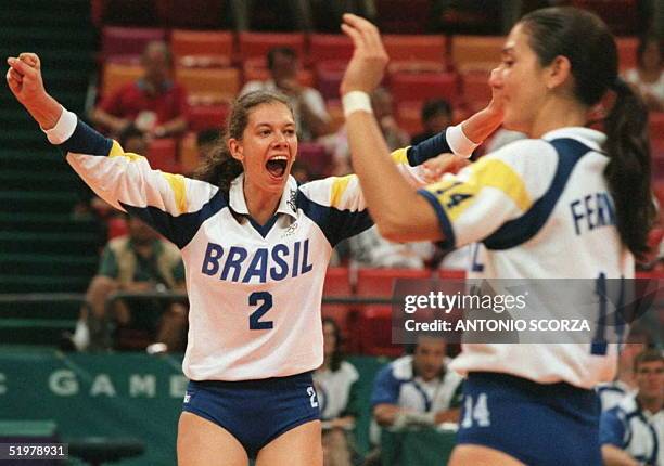 Brazilian players Ana Moser and Fernanda Venturini celebrate 28 July after their team defeated Germany in their Olympic volleyball preliminary Pool B...