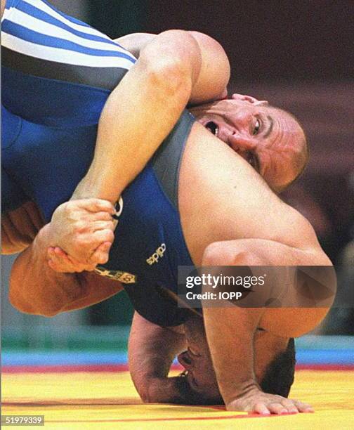 Russia's Alexander Karelin brings down Panayiotis Poikilidis of Greece during their 130kg semi-final Olympic wrestling match 23 July. The Siberian...