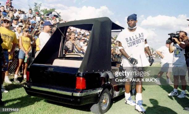 Deion Sanders of the Dallas Cowboys arrives for summer training camp in his custom-made Mercedes-Benz golf cart 21 July at St. Edwards University in...