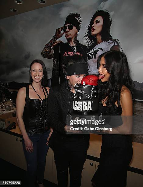 Owner of Rock Sugar Christy Horner looks on as guitarist Dj Ashba of Sixx:A.M. And his wife, model Nathalia Henao, eat cake during the grand opening...