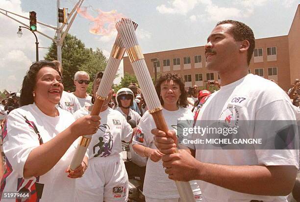 Coretta Scott King , widow of civil rights leader Martin Luther King, passes the Olympic Flame to her son Dexter Scott King 19 July in Atlanta. The...