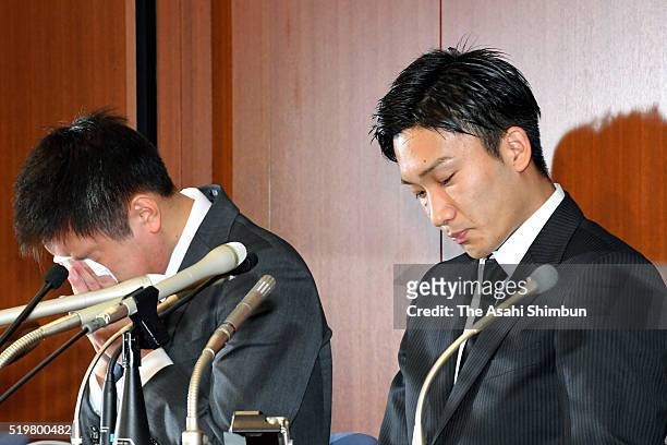 Badminton players Kenichi Tago wipes his eyes and Kento Momota looks on during a press conference on April 8, 2016 in Tokyo, Japan. Both players...