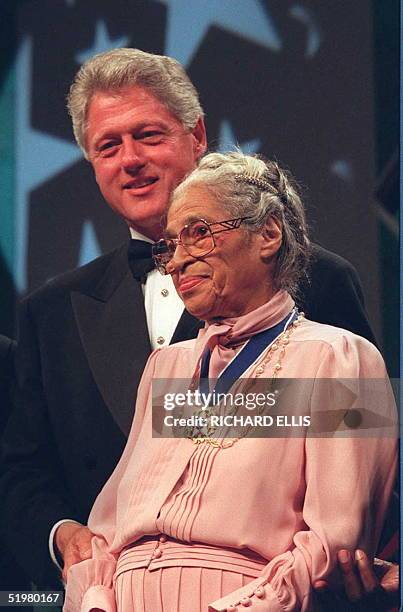 President Bill Clinton stands with civil rights activist Rosa Parks during the Congressional Black Caucus dinner 14 September in Washington DC....