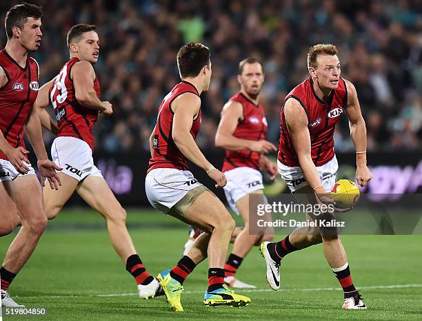 Adam Cooney of the Bombers handballs during the round three AFL match between the Port Adelaide Power and the Essendon Bombers at Adelaide Oval on...