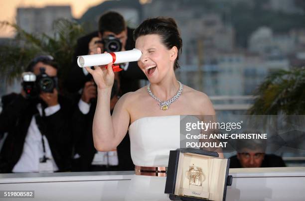 French actress Juliette Binoche poses after winning the Best Actress award for her role "Copie Conforme" during the closing ceremony at the 63rd...