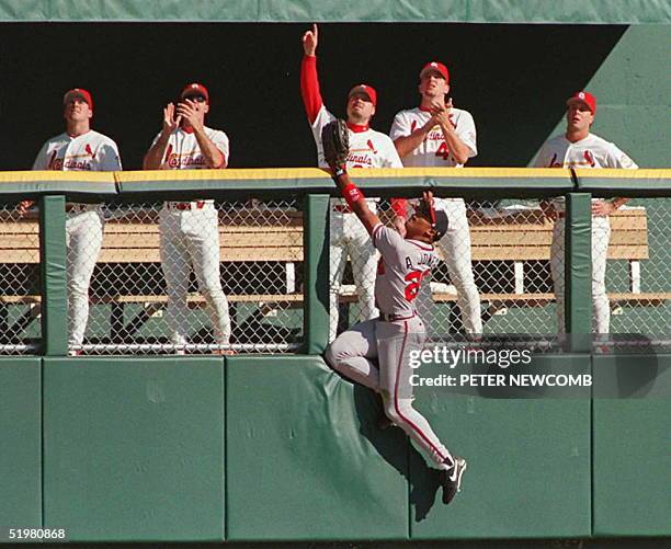 Atlanta Braves outfielder Andruw Jones can not get to a home run hit by St. Louis Cardinals Ron Gant as his teammates in the bull pen celebrate 12...