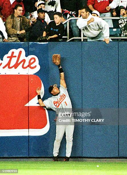 Baltimore Orioles' right fielder Tony Tarasco trioes to catch a fly ball from the New York Yankees' Derek Jeter 09 October but the ball is caught by...