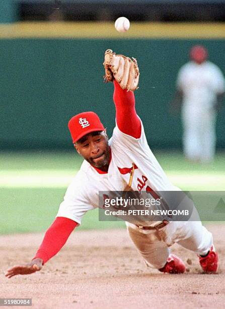 St. Louis Cardinals' Ozzie Smith knocks down a hit by the San Diego Padres Rickey Henderson 03 October during the sixth inning of their National...