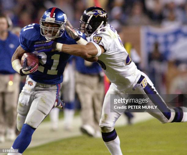 Baltimore Ravens' Rod Woodson tries to tackle New York Giant running back Tiki Barber during first half action of Super Bowl XXXV 28 January 2001 at...