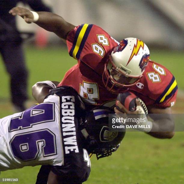 Orlando Rage tight end Terrance Huston is tackled by Chicago Enforcers linebacker Chike Egbuniwe during the first half of the new XFL league opening...