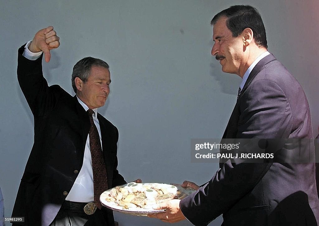 US President George W. Bush (L) gives a thumbs-dow