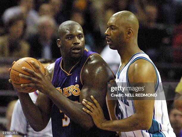 Los Angeles Laker center Shaquille O'Neal looks to pass against Charlotte Hornet center Elden Cambell in the second half at the Charlotte Coliseum in...