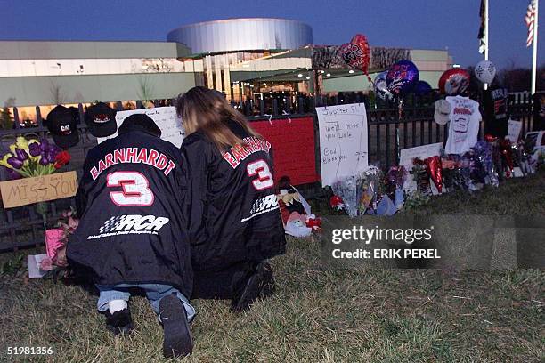 Fans Ronnie and Vickie Pethel of Concord, NC, say a prayer at a memorial outside driver Dale Earnhardt's corporate headquarters 19 February 2001 in...