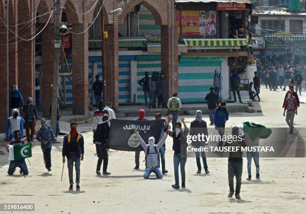 Kashmiri Muslim protesters hold Pakistani and ISIL flags as they shout anti-India slogans during clashes in downtown Srinagar on April 8,2016. -...