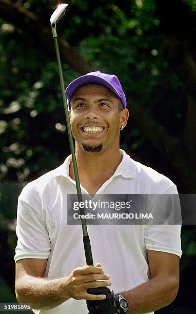 Ronaldo Nazario de Lima, star Brazilian soccer player and player for the Inter de Milan, smiles looking at his golf club during a tournament at the...