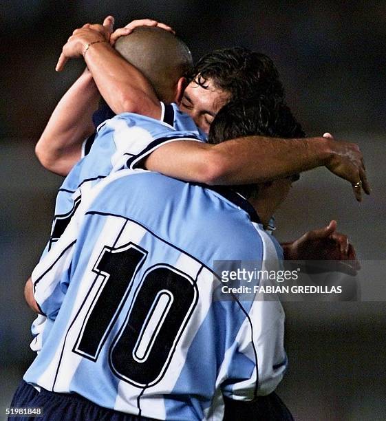 Juan Veron , who marked the third goal for Argentina, is huged by Marcelo Gallardo and Ariel Ortega in the Monumental Stadium of Buenos Aires,...