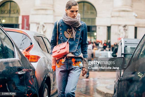 Danish model Caroline Brasch Nielsen exits the Ferragamo show at Piazza Affari wearing an embroidered denim jacket and jeans and a pink Chanel purse...