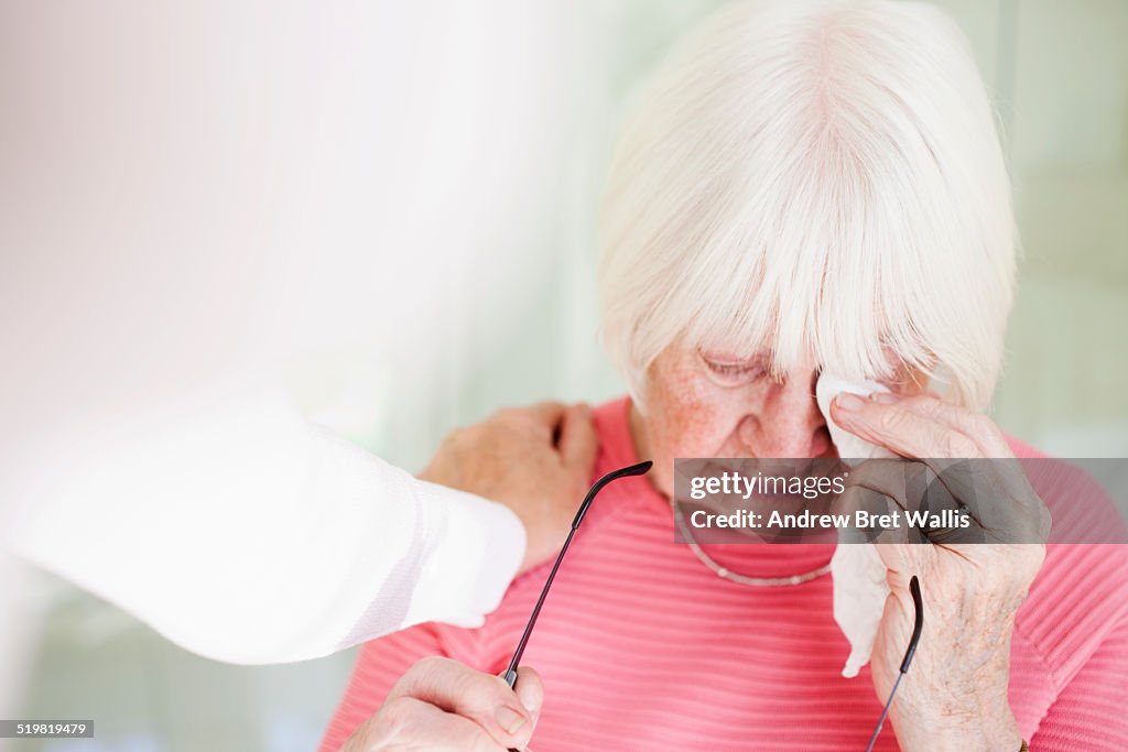 Senior woman consoled by her carer