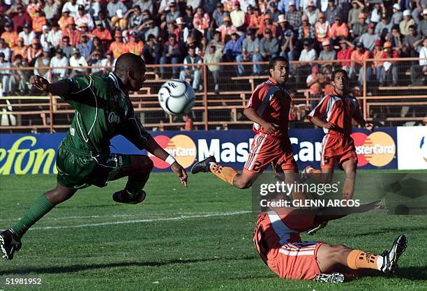 Elquin Murillo of Columbia's Cali team goes with the ball past Rodrigo Melendez of Chile's Cobreloa team, in the view of Mauricio Pozo , also of the...