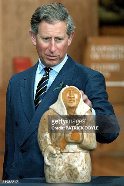 Prince Charles views an Inuit sculpture presented to him by Hertiage Minister Sheila Copps 25 April 2001 during a visit to the Museum of Civilization...