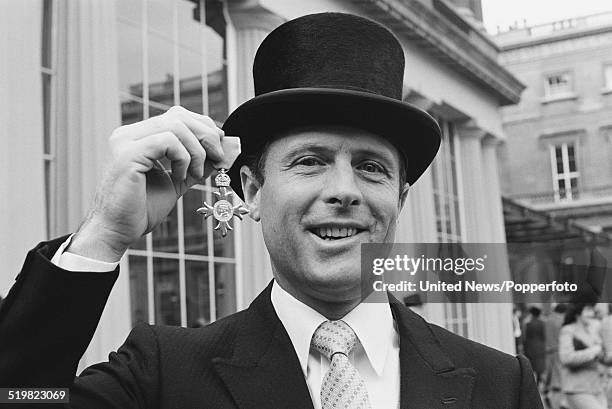 English cricketer Geoffrey Boycott holds his OBE at an investiture ceremony at Buckingham Palace in London on 11th November 1980.