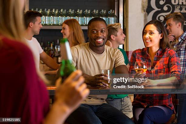 young couple drinking in a bar - busy pub stock pictures, royalty-free photos & images