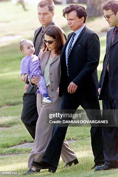 Actor Robert Blake , walks to the gravesite of his slain wife, Bonny Lee Bakley, with his 11-month-old daughter Delinah, carrying the child he...