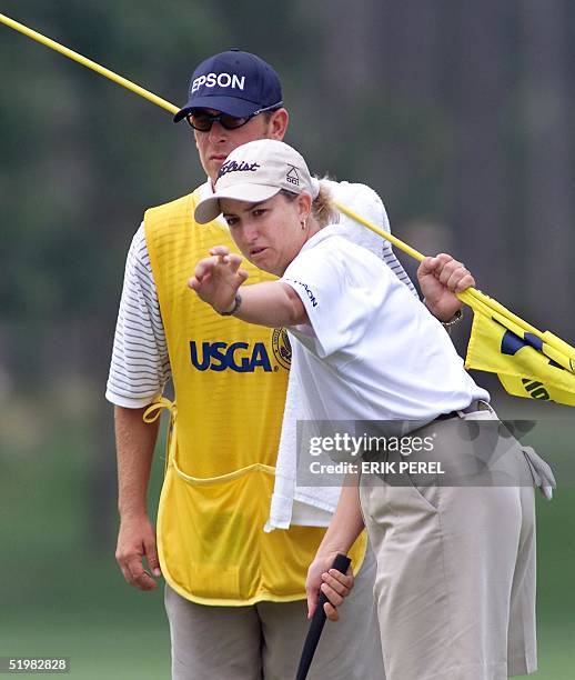 Golfer Karrie Webb of Australia lines up a putt with the assistance of her caddie, Mike Patterson, on the 14th hole 1 June 2001 during the second...