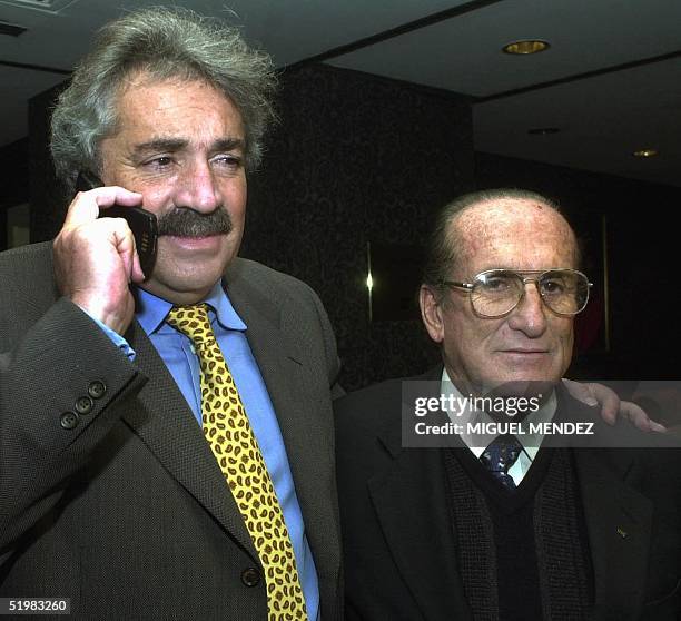 President of the Colombian Soccer Federation, Alvaro Fina , talks on a cellular phone while he poses for photographers with the vice president of...